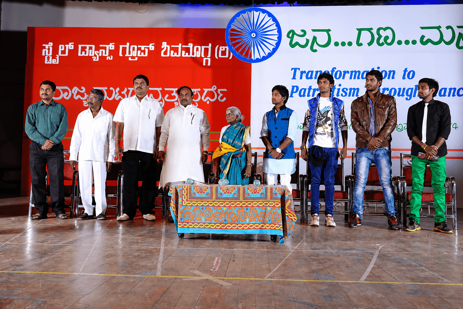 Style Dance Crew Studio dancers performing synchronized hip-hop choreography on stage with professional stage lighting at a live community event in Shivamogga