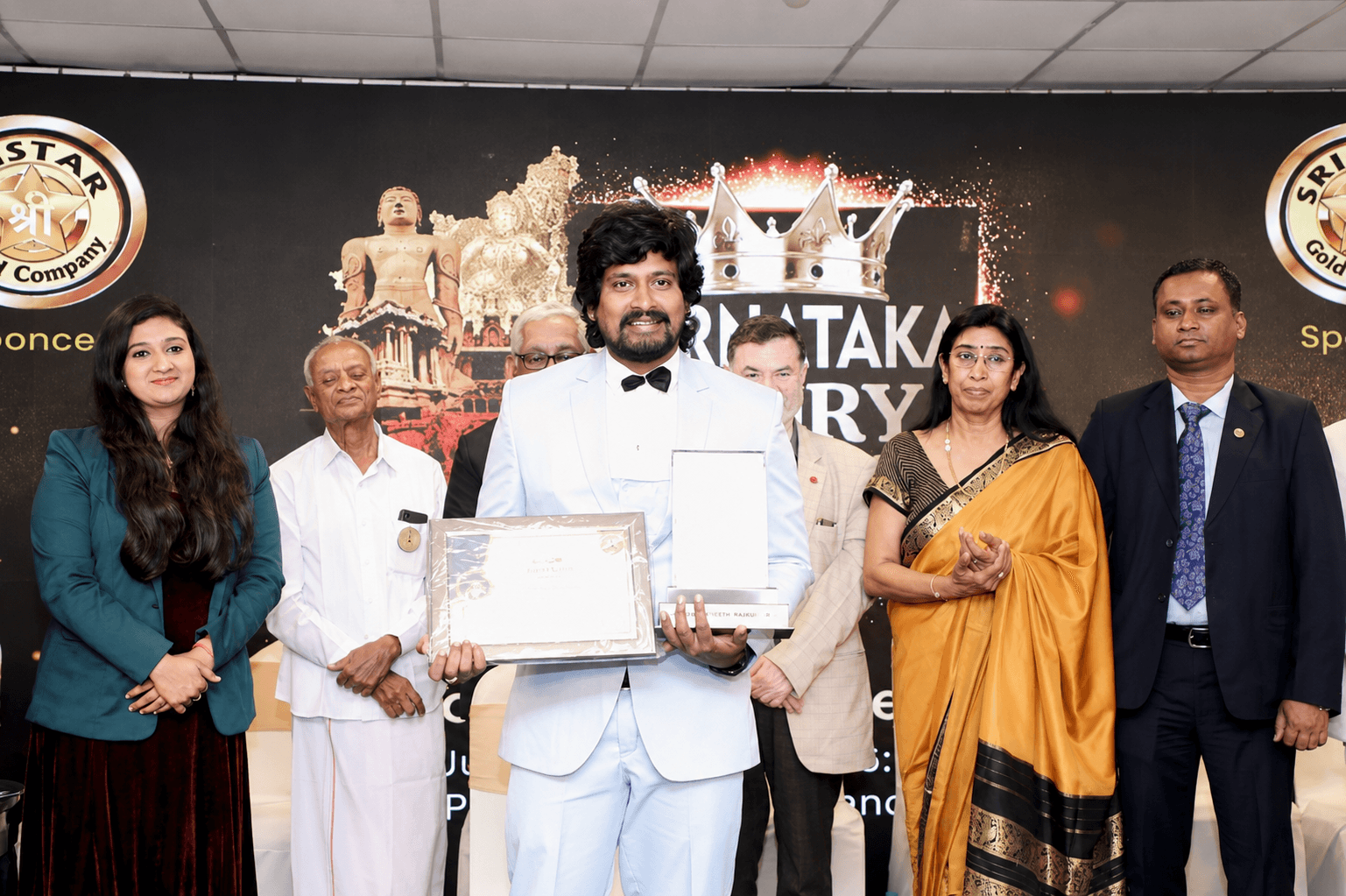 Shashikumar N. receiving an award on stage at a felicitation ceremony.